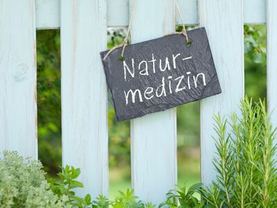 Schild Naturmedizin hängt an Zaun